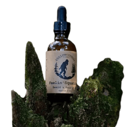 Amber bottle of beard oil sitting on tree-Winchester Creek Farm